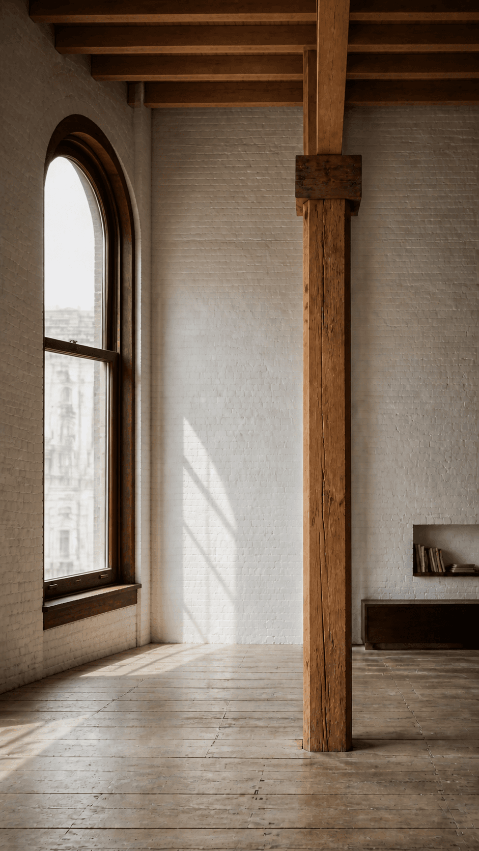 Interior of a New York loft with an exposed timber beam and arched window